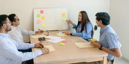 B2B team planning around a whiteboard growth chart